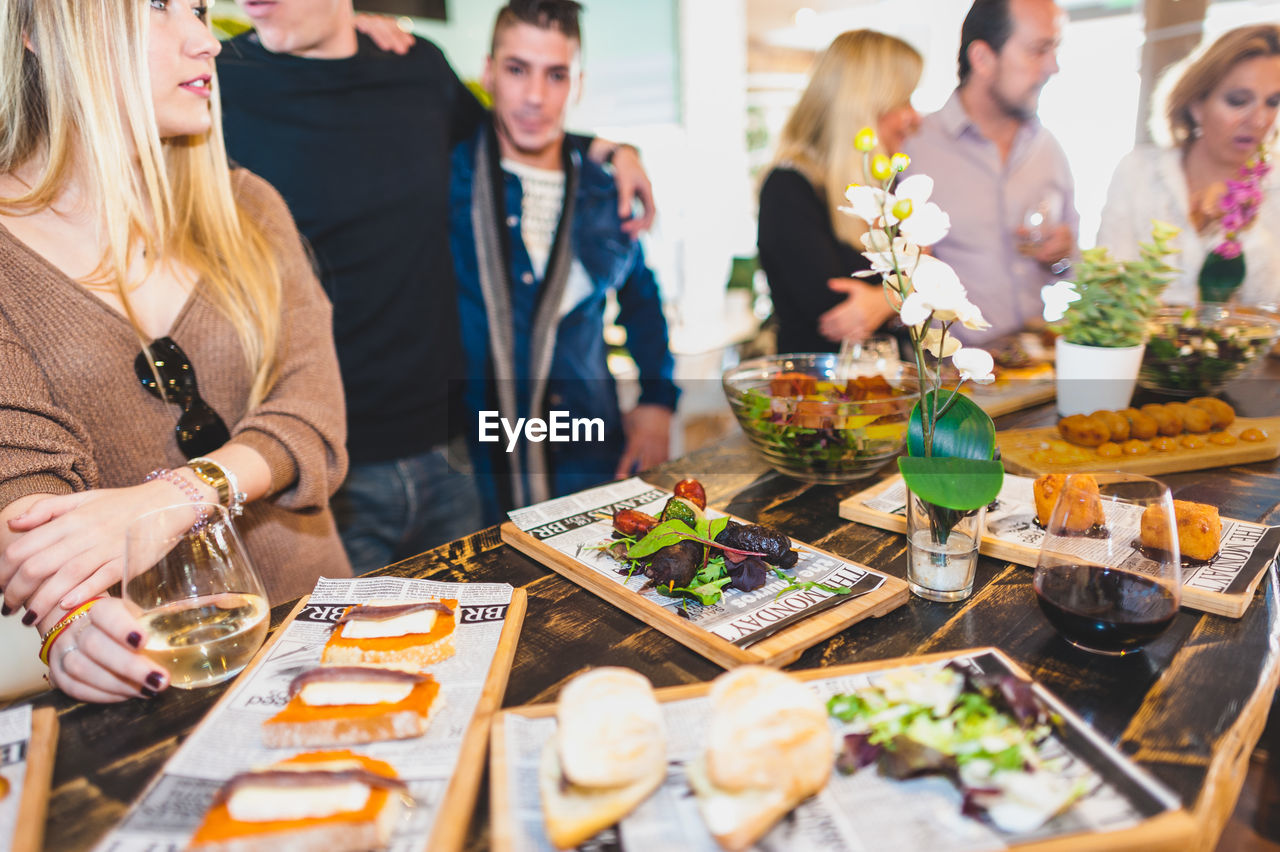 Food on table with friends in background at restaurant