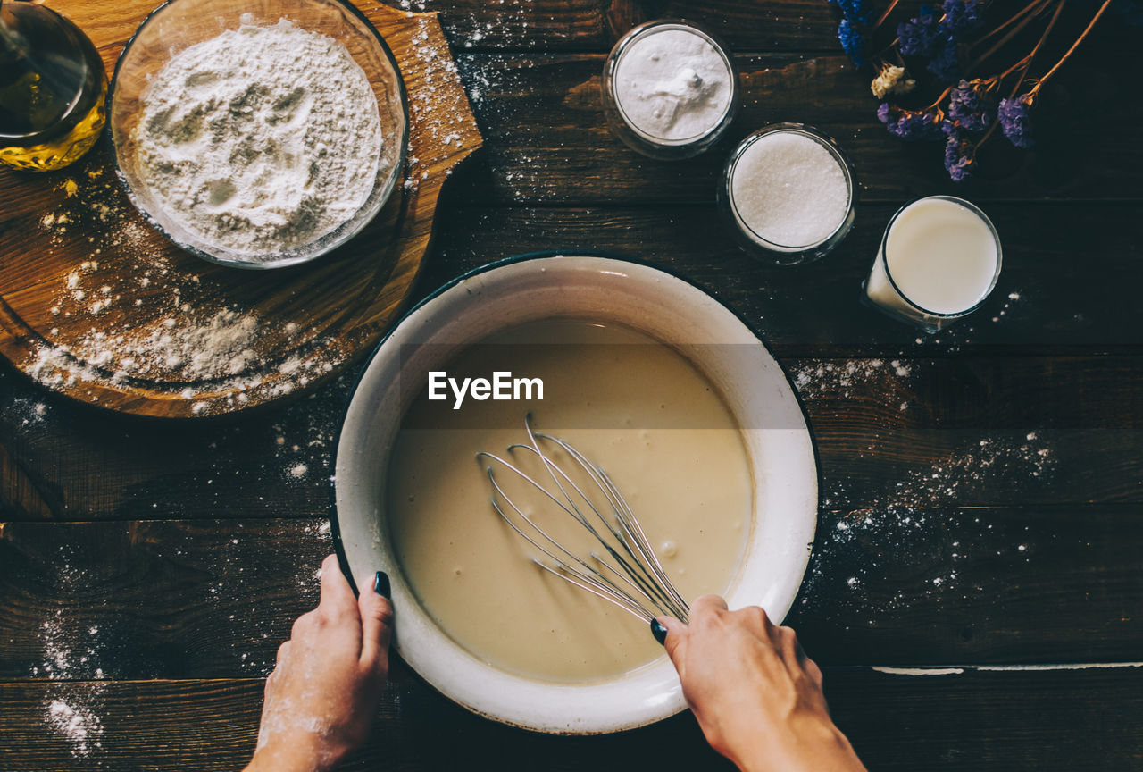 HIGH ANGLE VIEW OF PERSON PREPARING FOOD AT TABLE