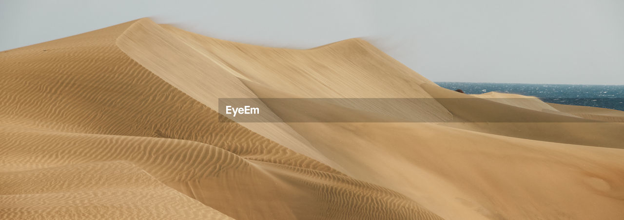 Close-up of sand at beach against sky