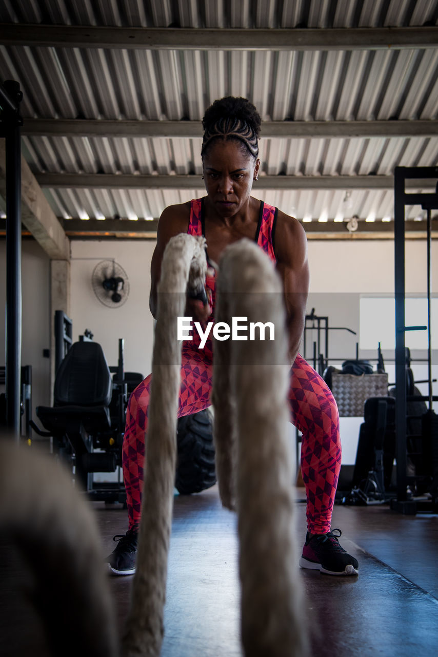 Woman doing training with naval rope. abdominal strengthening and muscular endurance.