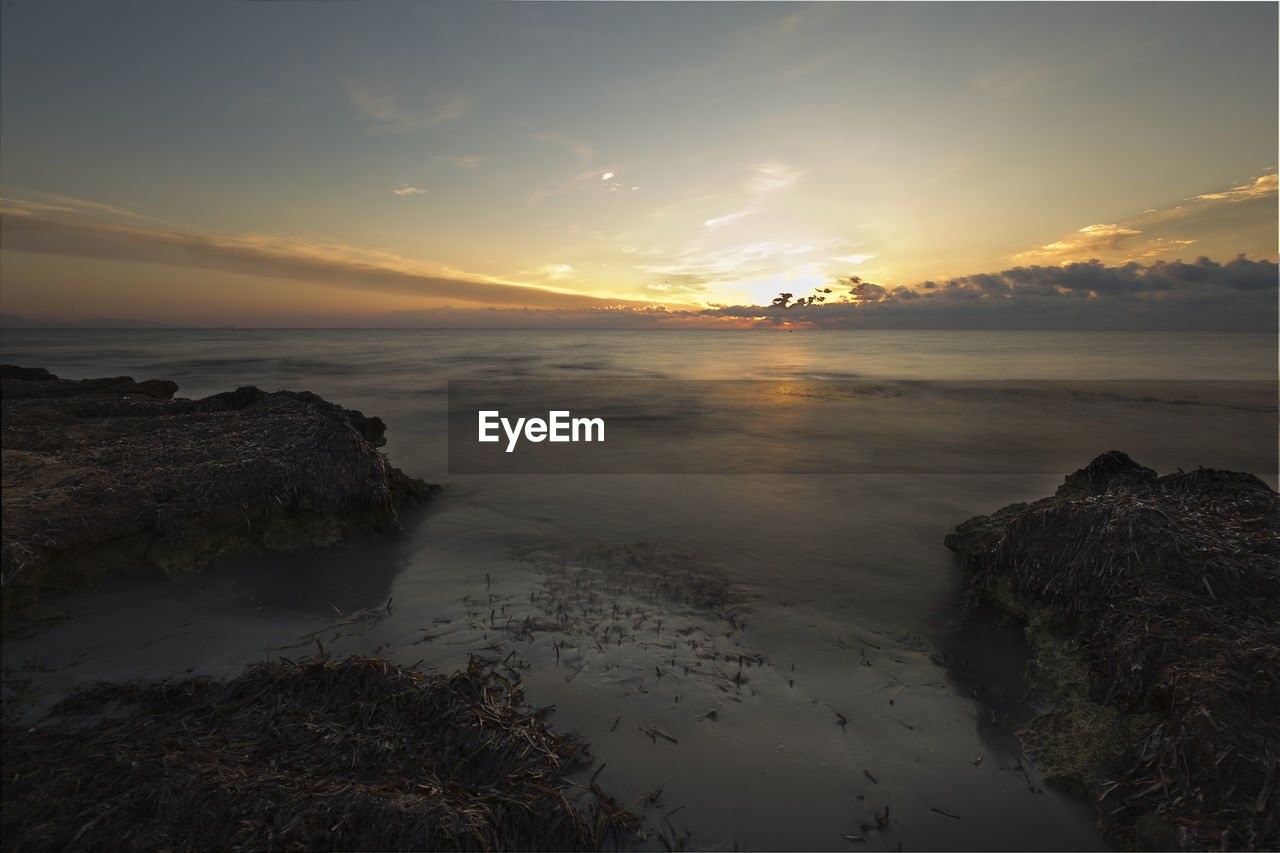 Scenic view of beach against sky during sunset