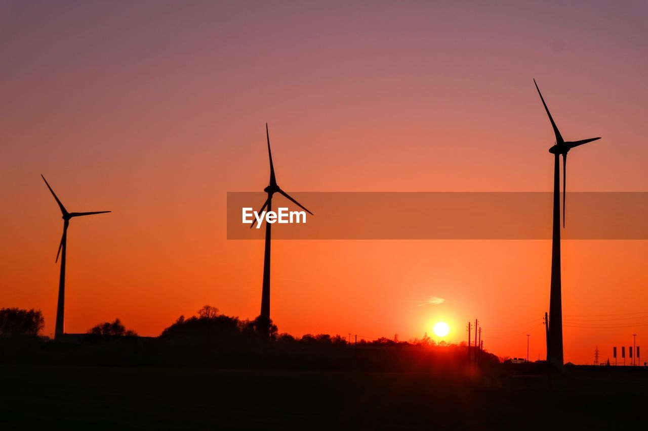 Silhouette of wind turbines at sunset