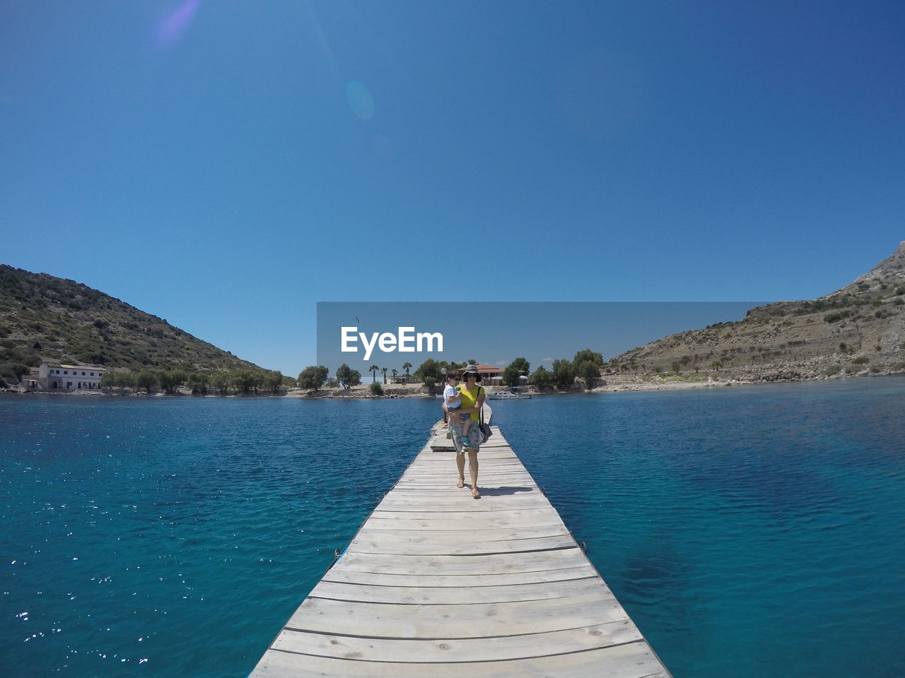 Scenic view of lake against clear blue sky