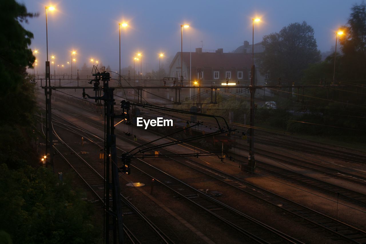 Illuminated railroad tracks at dusk