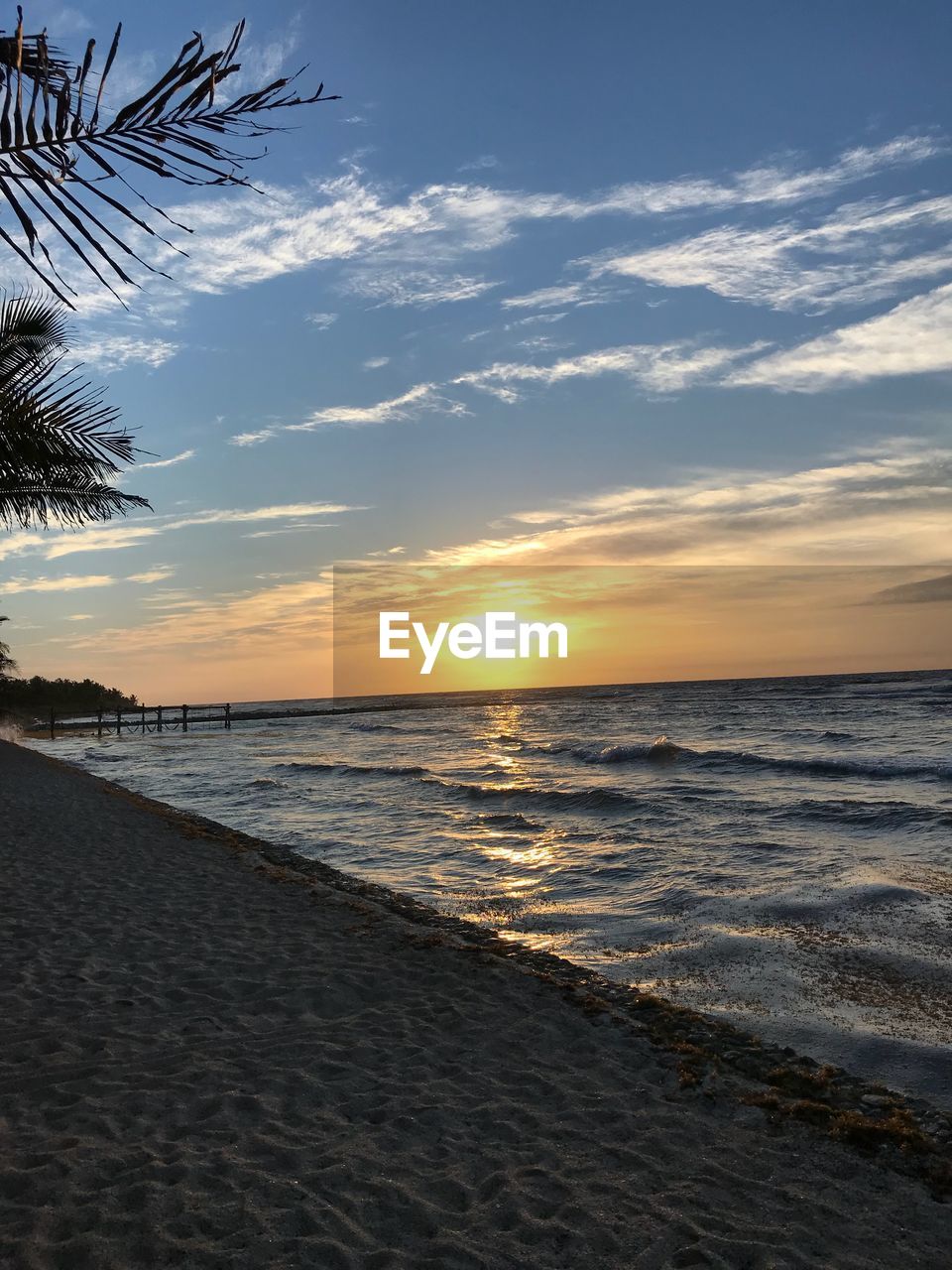 SCENIC VIEW OF BEACH AT SUNSET