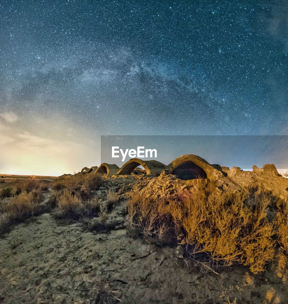 Rock formation on landscape against sky at night