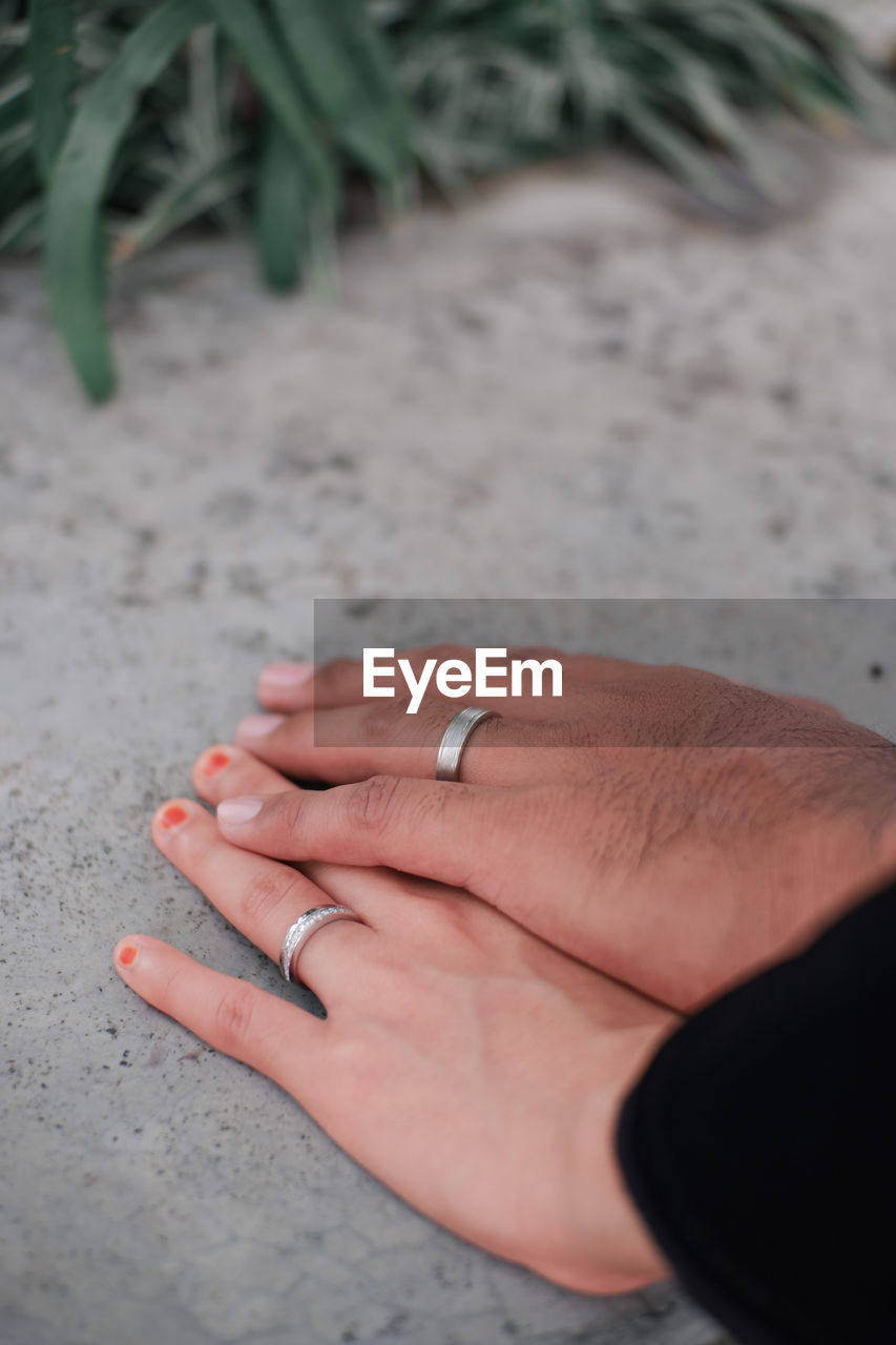 Holding hands with engagement ring on finger