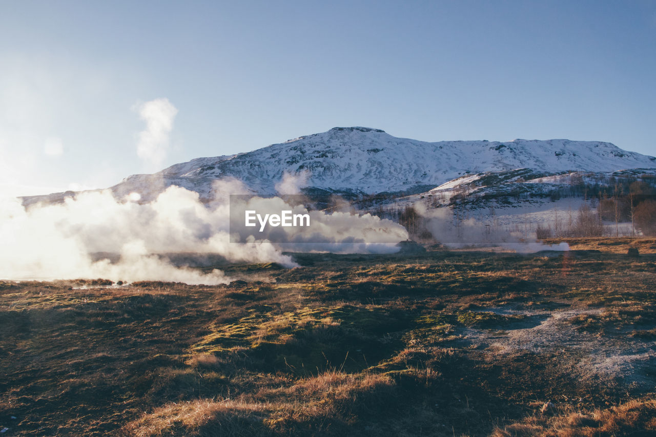 Scenic view of steam and mountain against sky