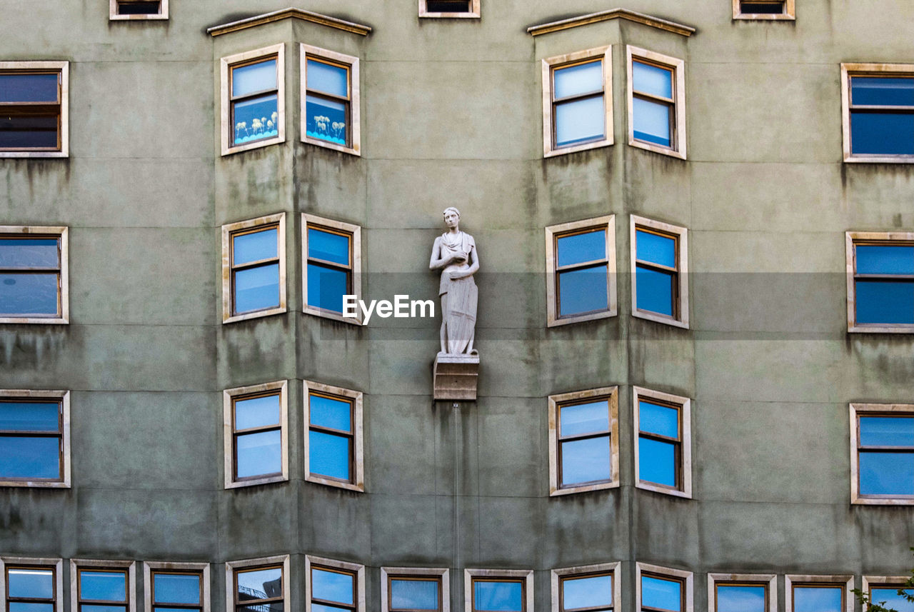 Low angle view of statue against building, barcelona. 