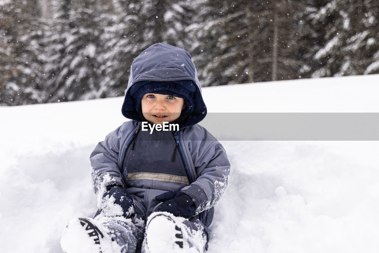 portrait of young man skiing on snow covered field