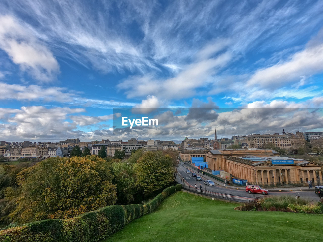 Panoramic view of field and buildings against sky