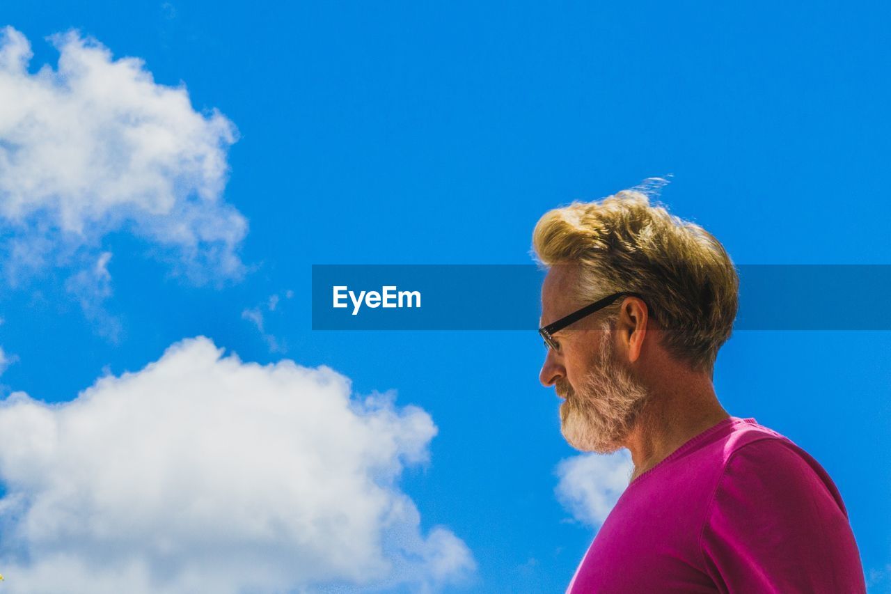 Low angle view of man wearing sunglasses against sky