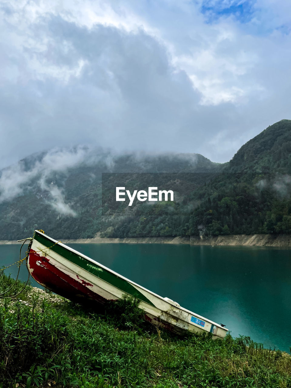 SCENIC VIEW OF LAKE BY MOUNTAIN AGAINST SKY