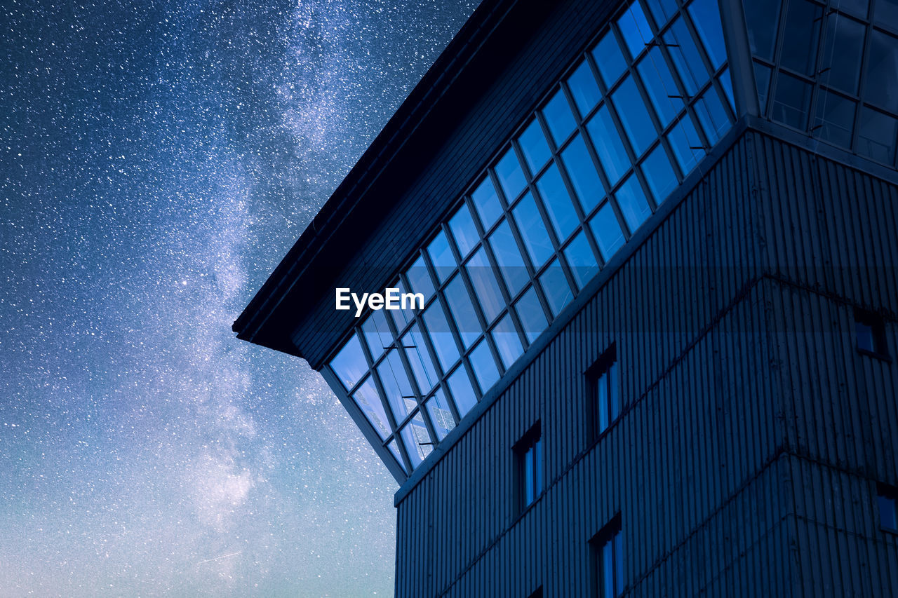 Low angle view of modern building against blue sky