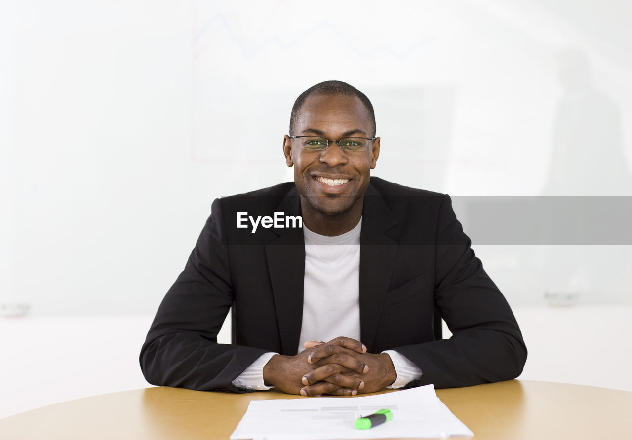 Portrait of smiling businessman sitting at desk