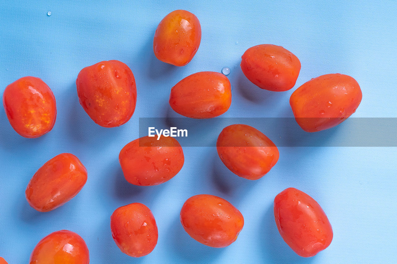 Group of cherry tomatoes isolated on blue background. 