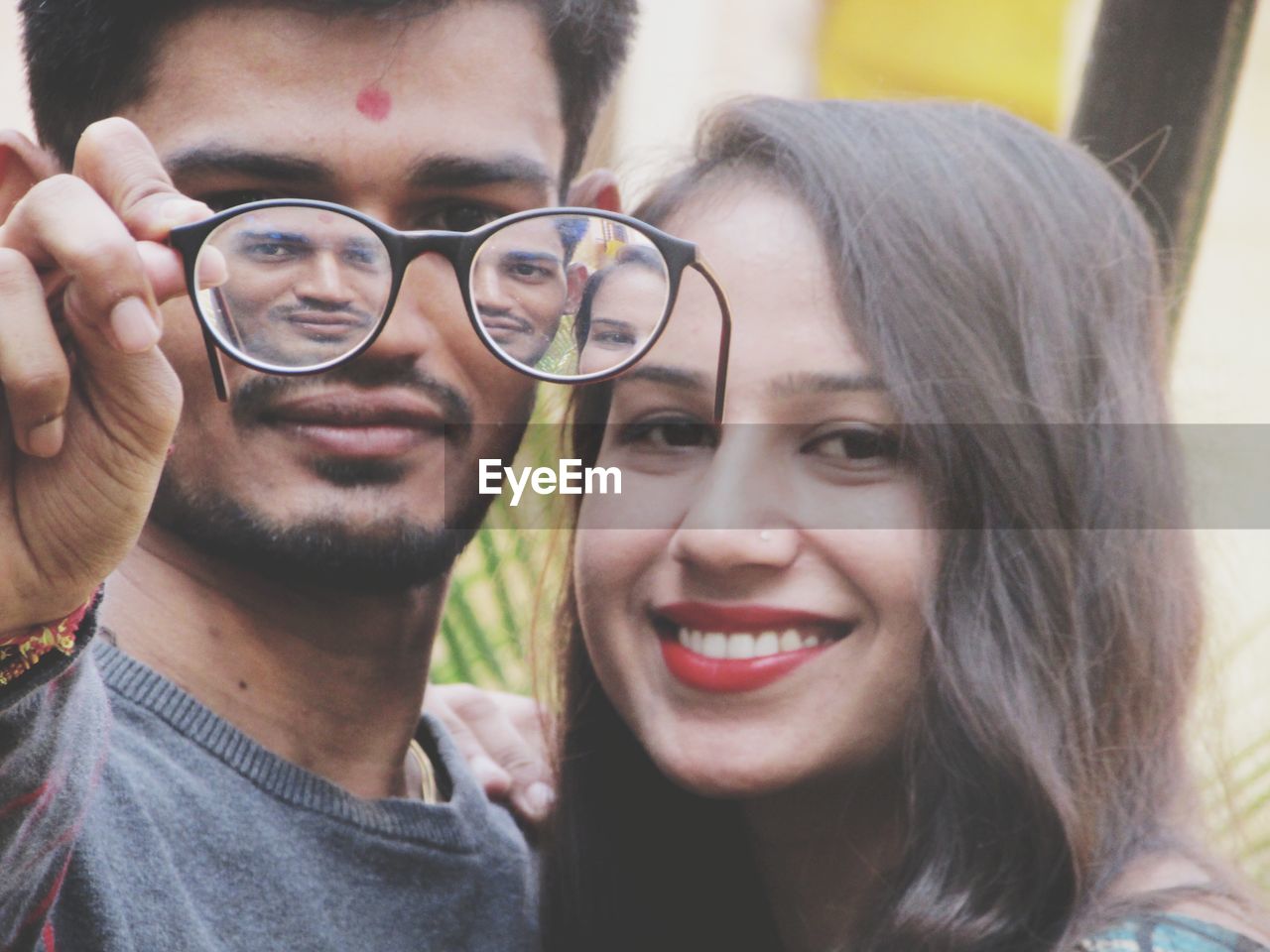 Reflection of smiling young couple in eyeglasses 