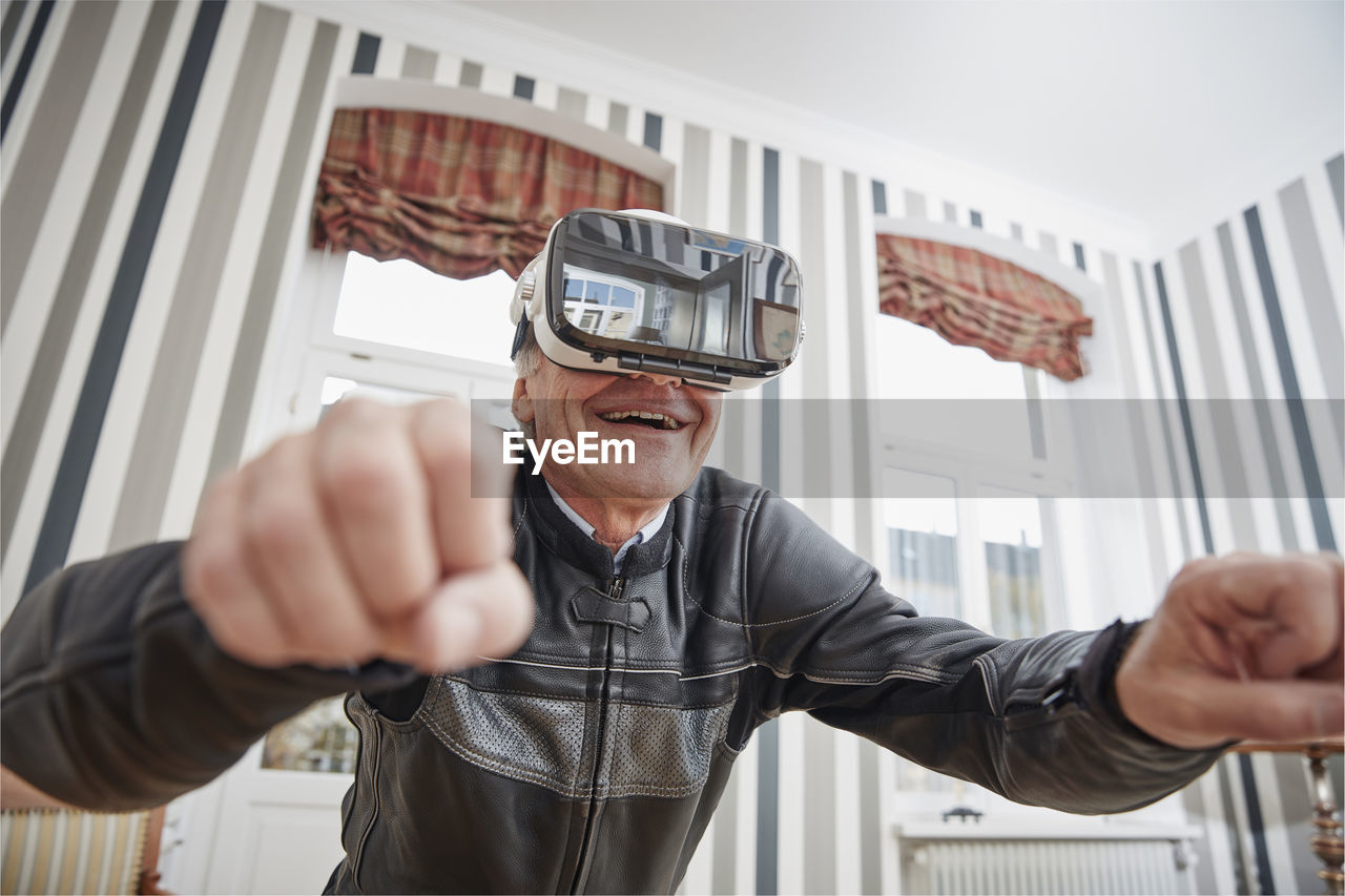 Senior man in motorcycle suit wearing vr glasses