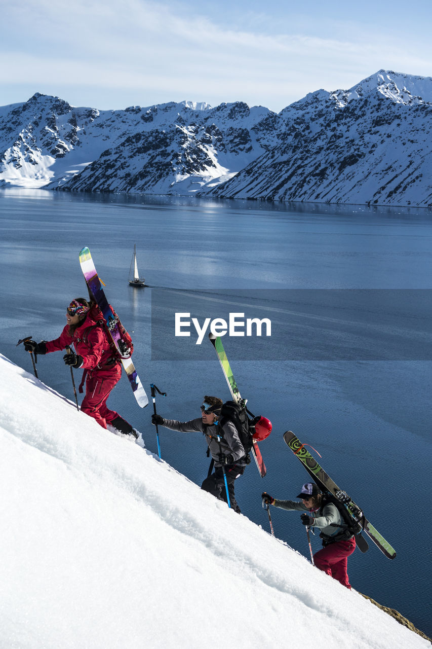 Group of friends skinning up mountain to ski in svalbard