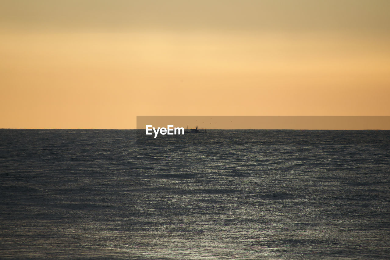 SCENIC VIEW OF SEA AGAINST SKY AT SUNSET