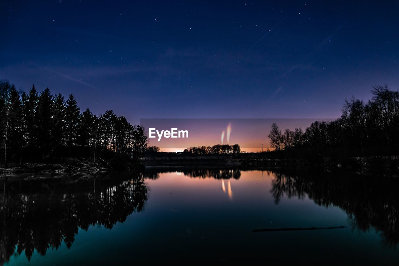 Scenic view of lake against sky at night