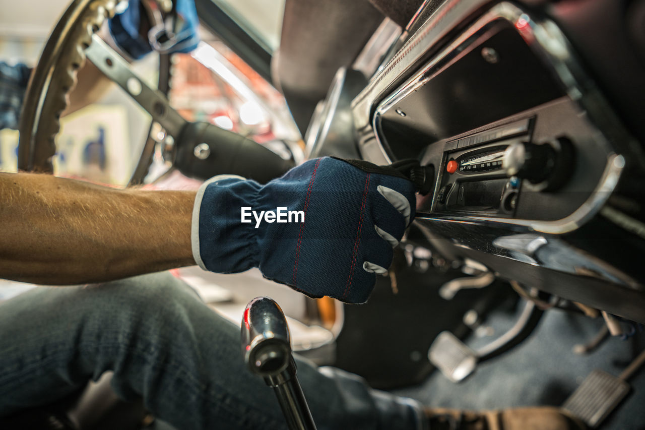 cropped hands of man repairing car