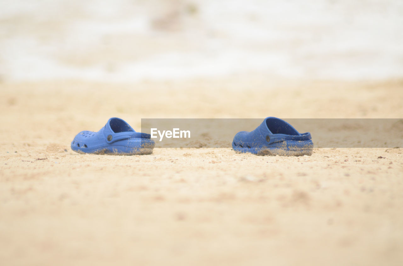 Close-up of shoes on sand