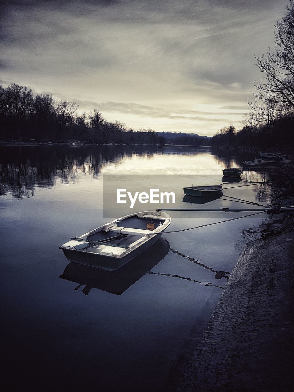 BOAT MOORED AT LAKE AGAINST SKY