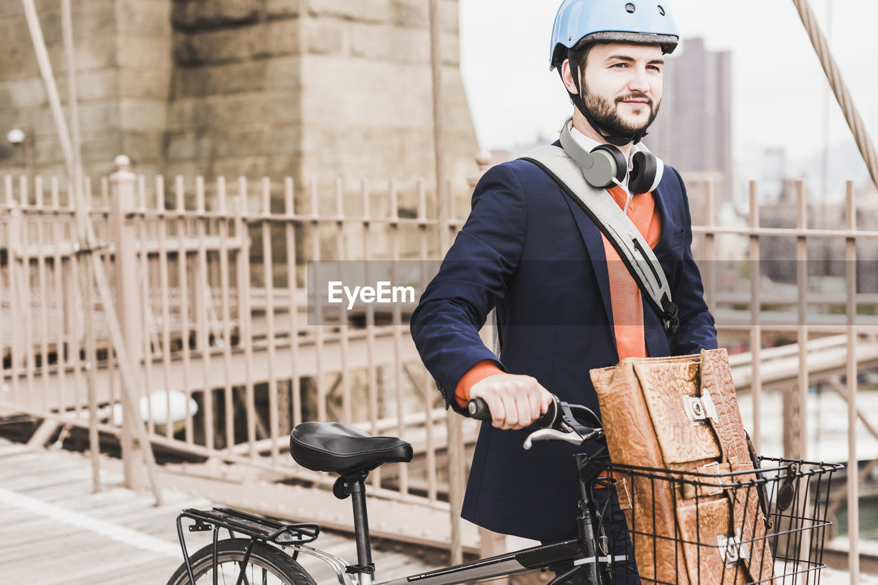 Usa, new york city, man with bicycle on brooklyn bridge