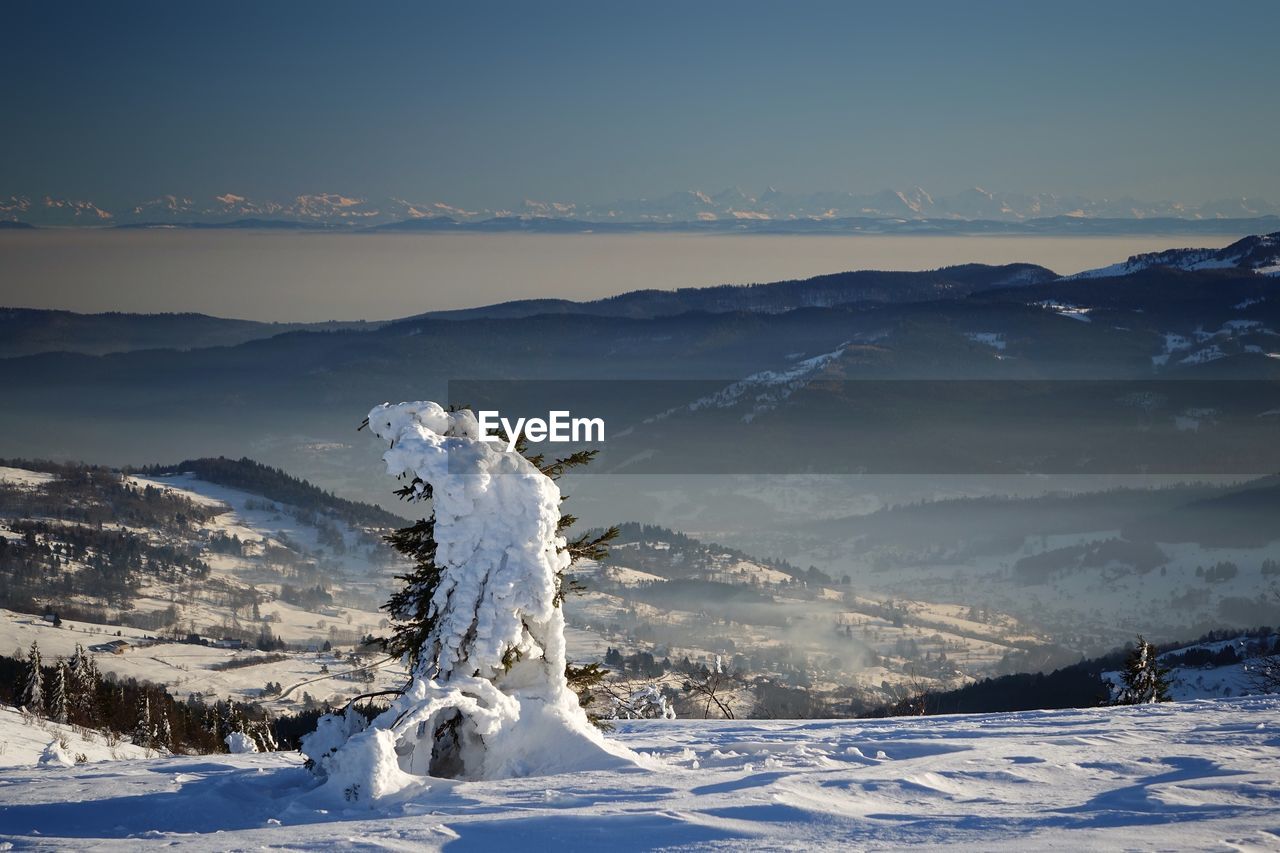 Snow covered landscape against mountain range