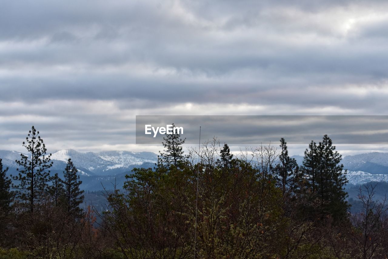 Snow dusted mountains pushed to the back of a chilly stratus landscape