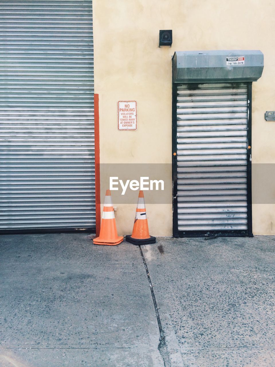 Traffic cones on sidewalk against garage