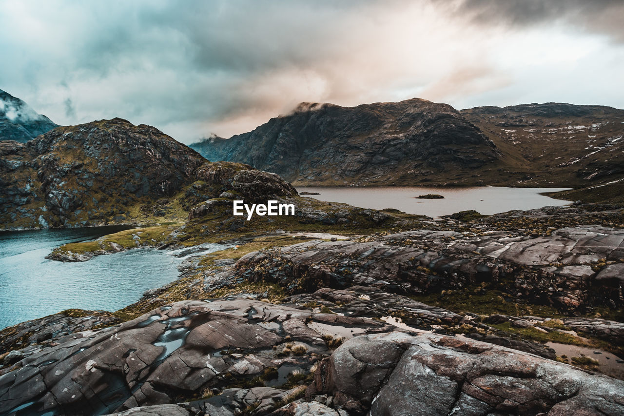 Scenic view of sea and mountain against sky