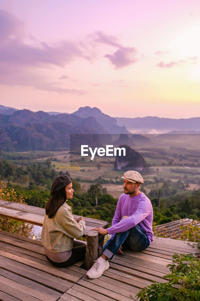 rear view of woman sitting on mountain