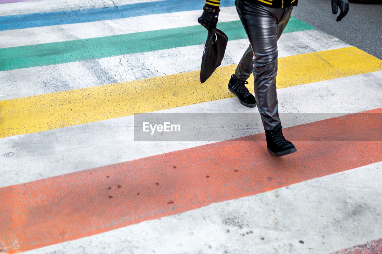 Low section of person walking on road marking