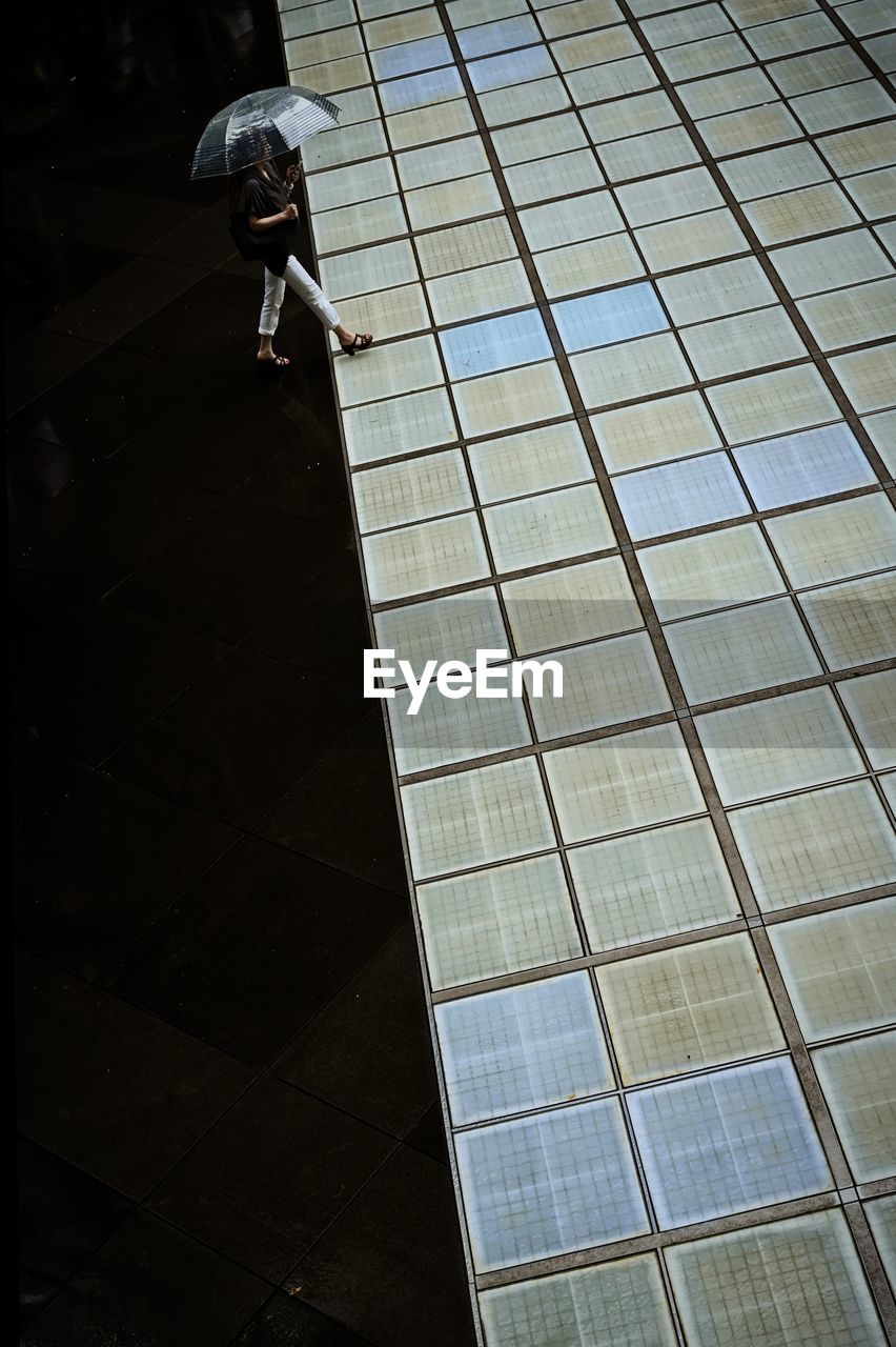 HIGH ANGLE VIEW OF WOMEN WALKING ON TILED FLOOR