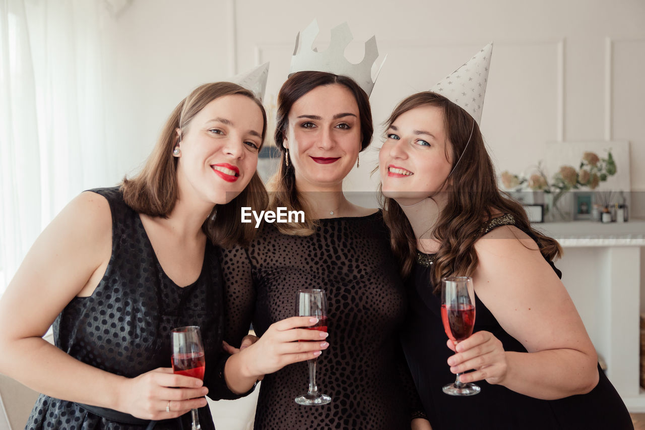 Portrait of smiling woman with friends celebrating at home