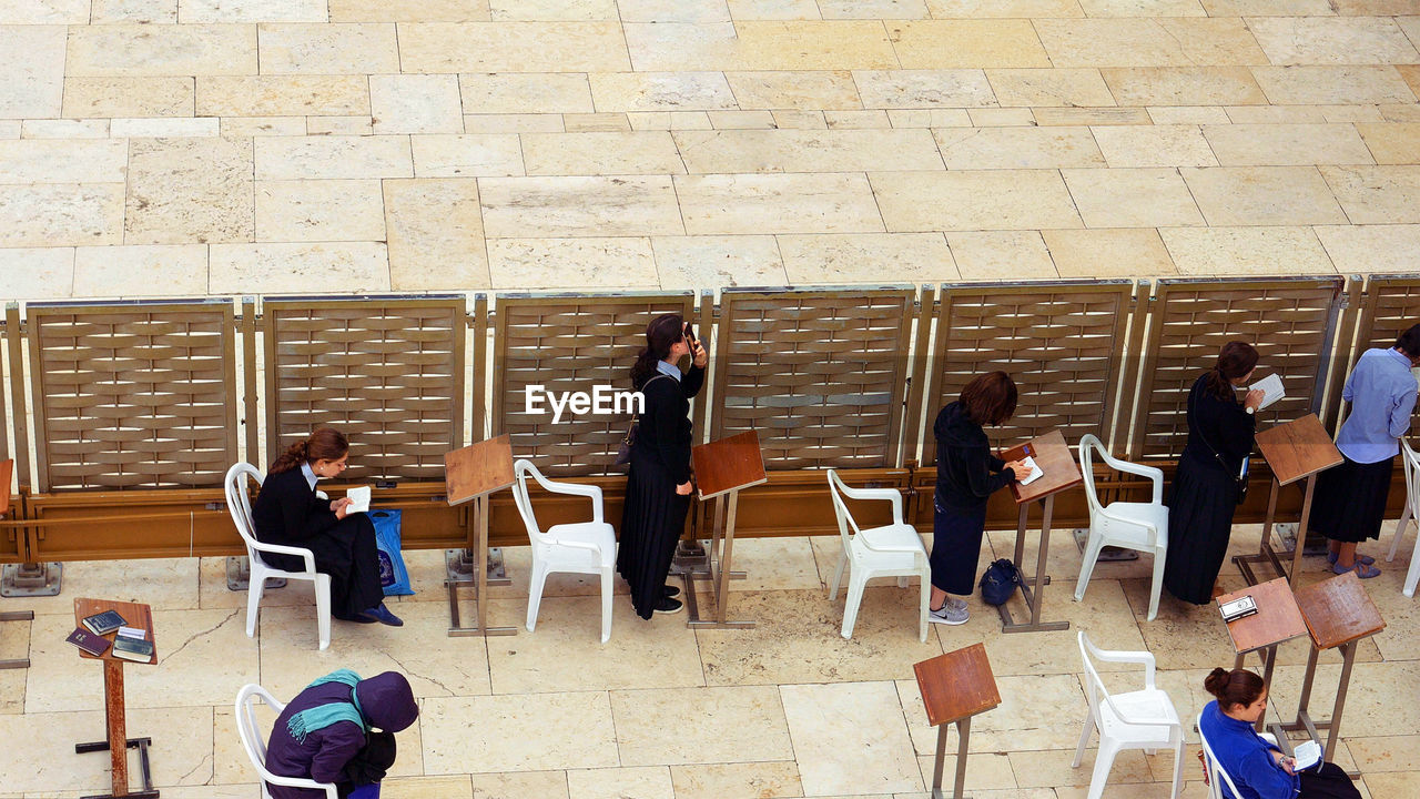 GROUP OF PEOPLE SITTING ON CHAIR