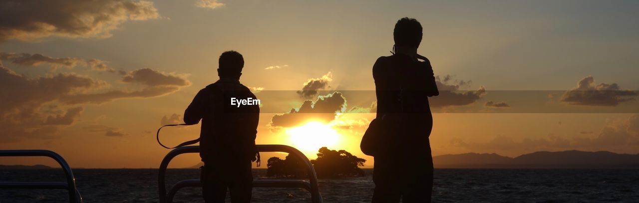 SILHOUETTE PEOPLE AGAINST SEA DURING SUNSET