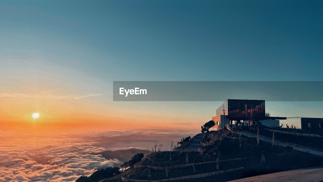horizon, sky, sunrise, architecture, dawn, sea, nature, morning, built structure, ocean, sunlight, travel destinations, building exterior, transportation, travel, coast, beauty in nature, outdoors, scenics - nature, sun, blue, reflection, copy space, no people, mountain, city, cloud, water
