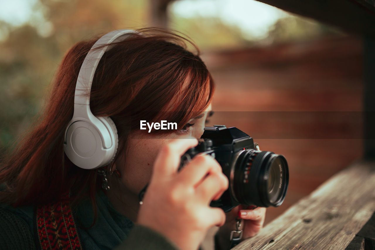 PORTRAIT OF WOMAN HOLDING CAMERA