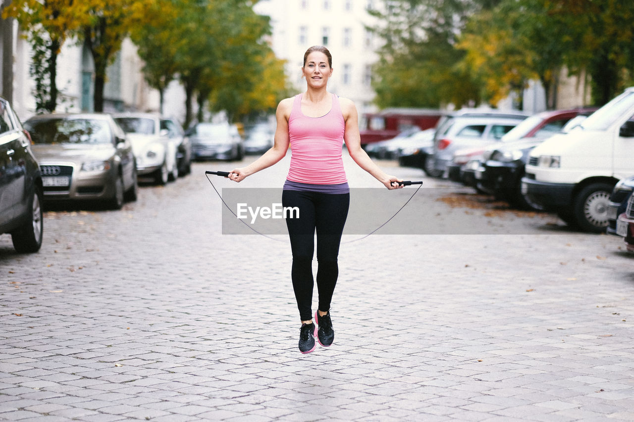 WOMAN STANDING ON TREE TRUNK