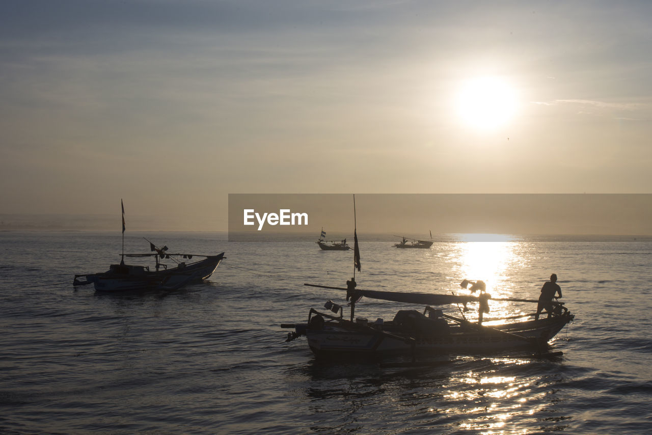 Scenic view of fishing boats during sunrise