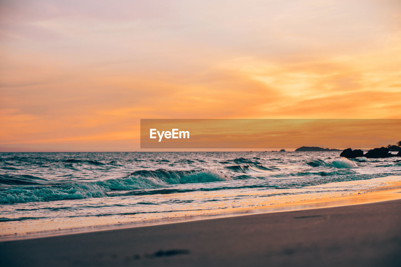 SCENIC VIEW OF SEA AGAINST ORANGE SKY