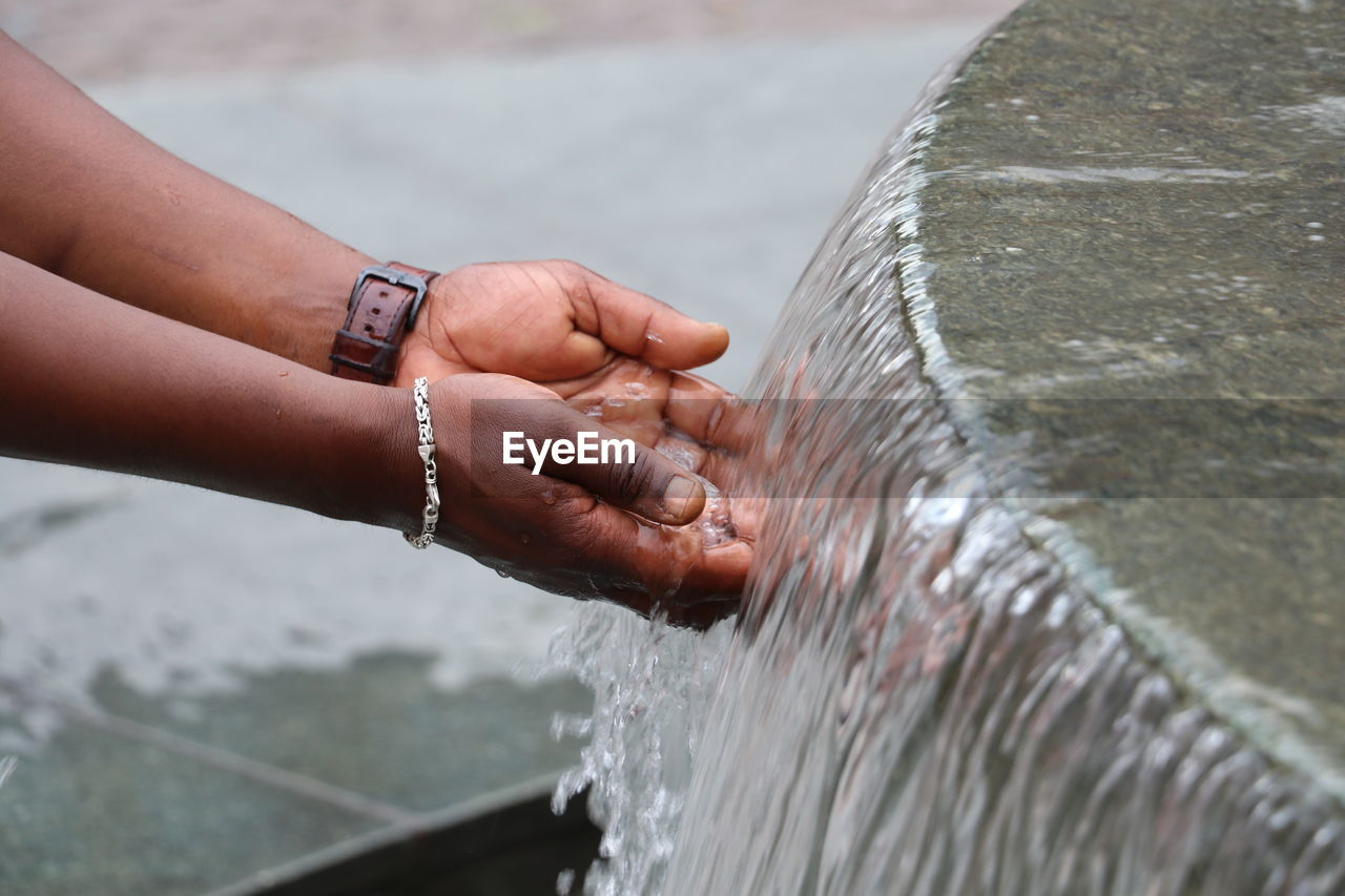 Close-up of hands holding water fountain