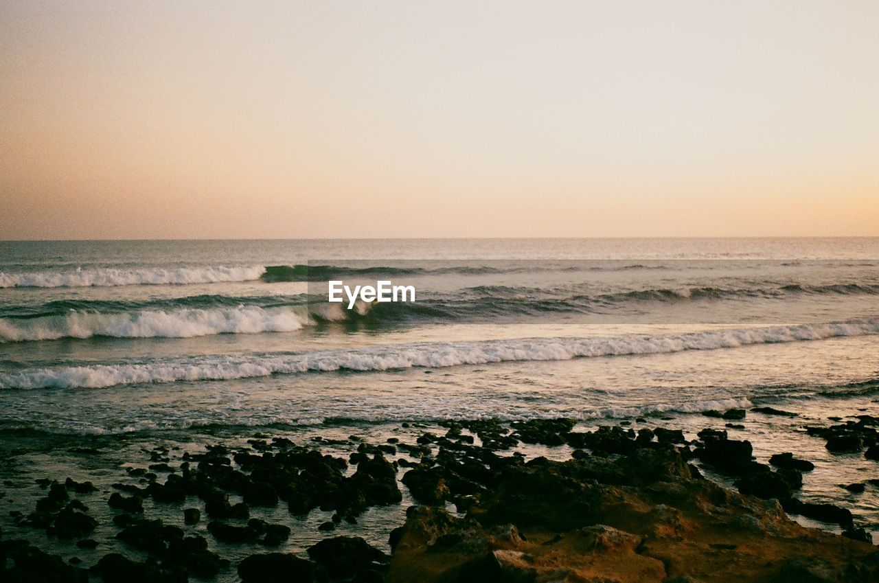 Scenic view of sea against clear sky during sunset