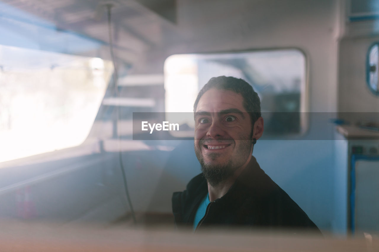 Portrait of man seen through window of camper trailer