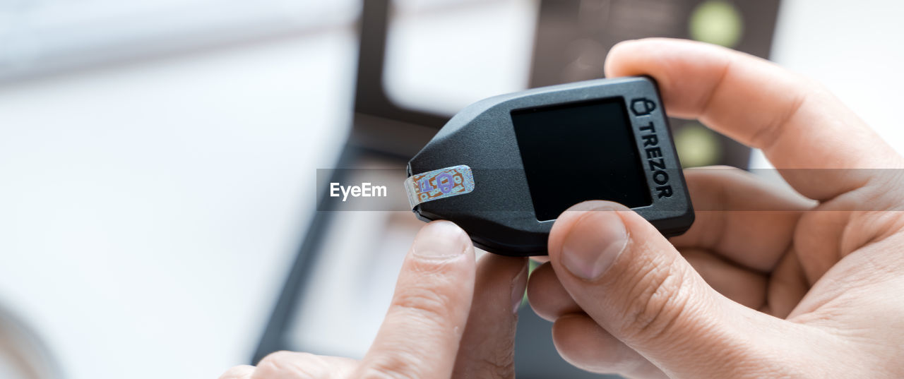 Cropped hands holding hardware wallet