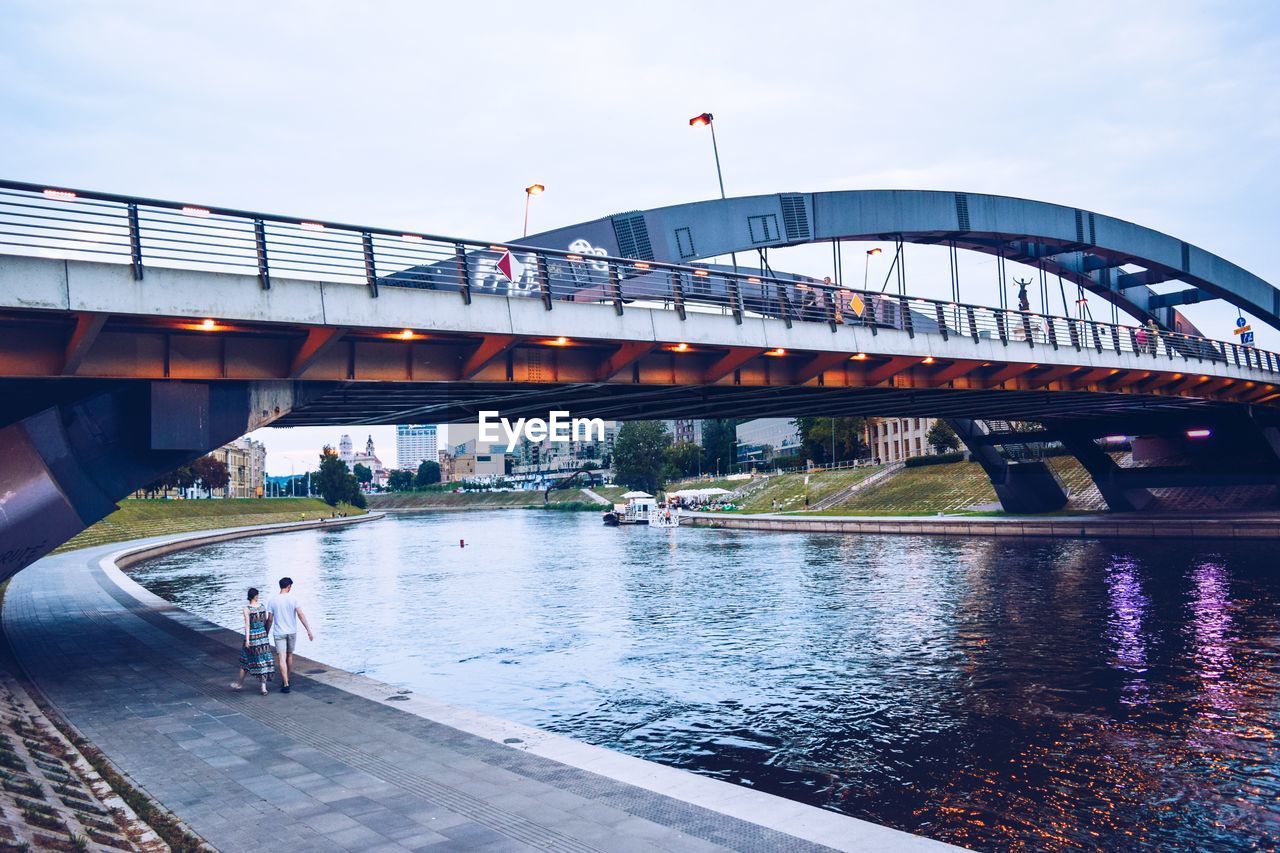 BRIDGE OVER RIVER IN CITY AGAINST SKY