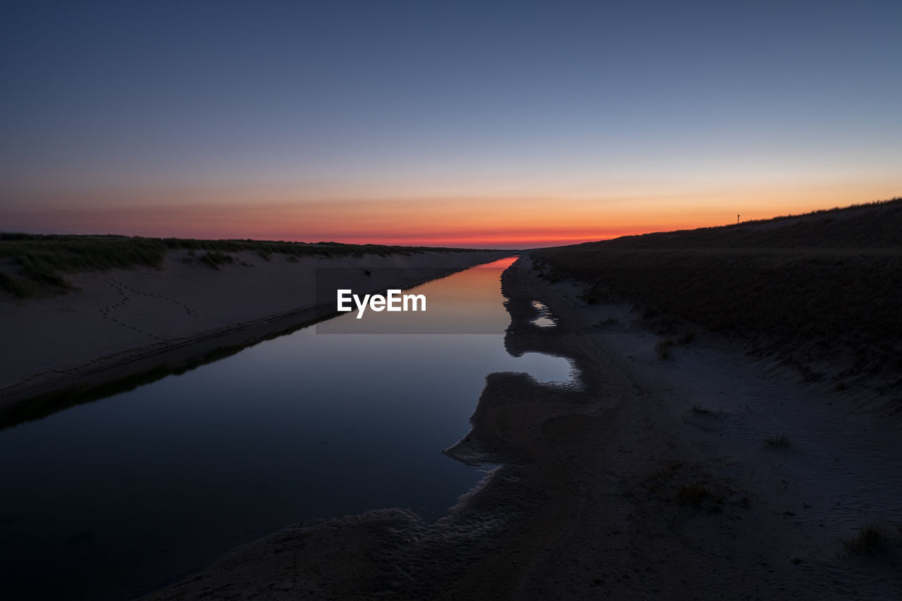 Scenic view of lake against sky during sunset